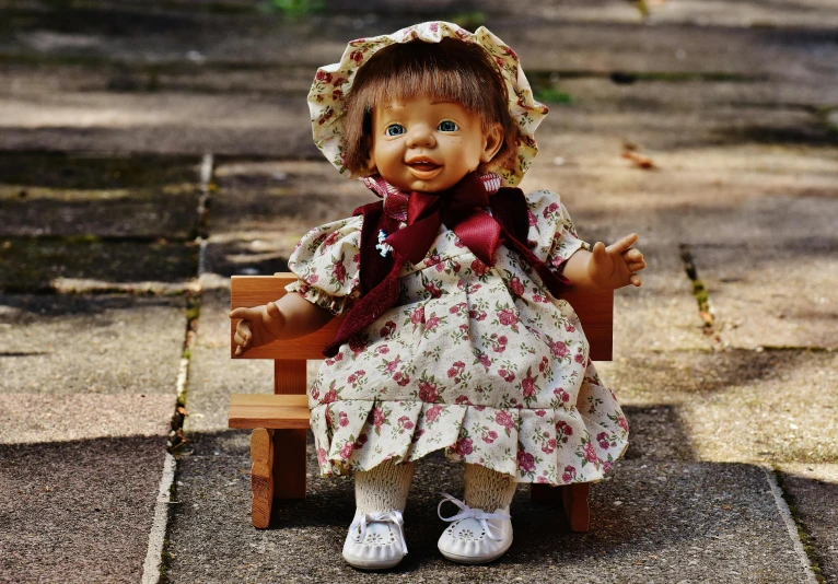 a doll sitting on top of a wooden bench, by Lucia Peka, pixabay contest winner, cute decapodiformes, dressed in a flower dress, 1997, square