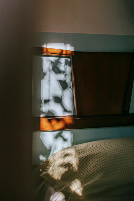 a bed room with a neatly made bed and a window, an abstract sculpture, inspired by Nan Goldin, unsplash, luminous veins, backlit stained glass, abstract detail, caustic projection