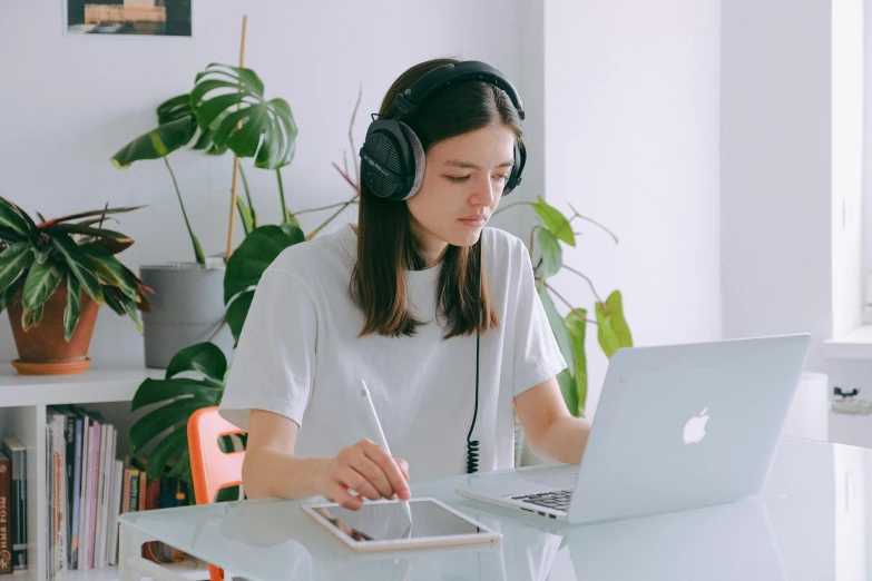 a woman sitting at a table with a laptop and headphones, trending on pexels, applepencil, avatar image, pokimane, studious