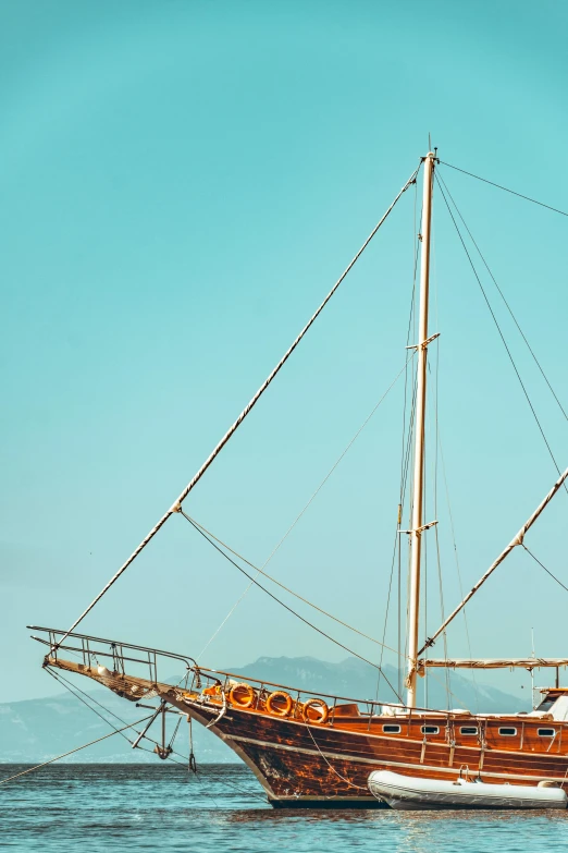 a large boat floating on top of a body of water, zoomed in, sailboat, at the sea, exterior shot