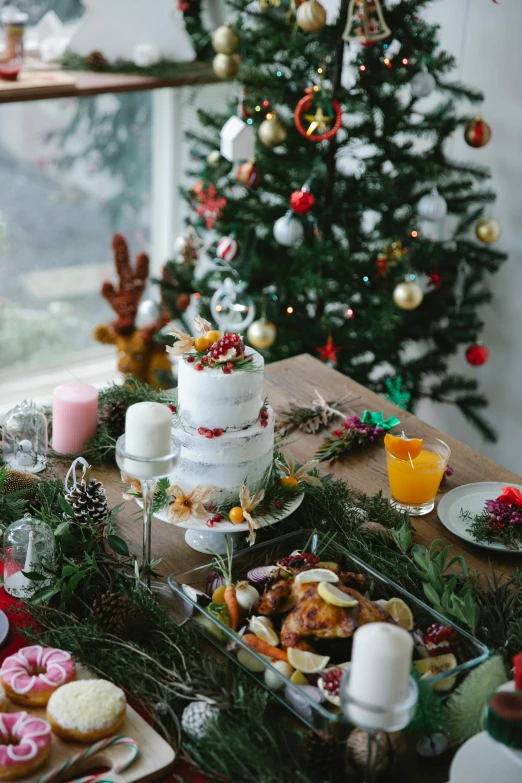 a table topped with lots of food next to a christmas tree, by Lucette Barker, cake, natural lights, profile image, rustic