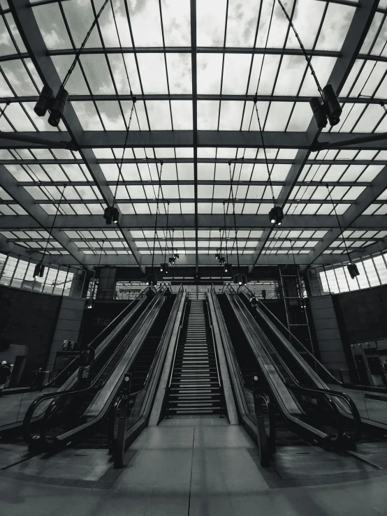 a black and white photo of an escalator, inspired by Thomas Struth, unsplash contest winner, square, skies, industrial aesthetic, promo image