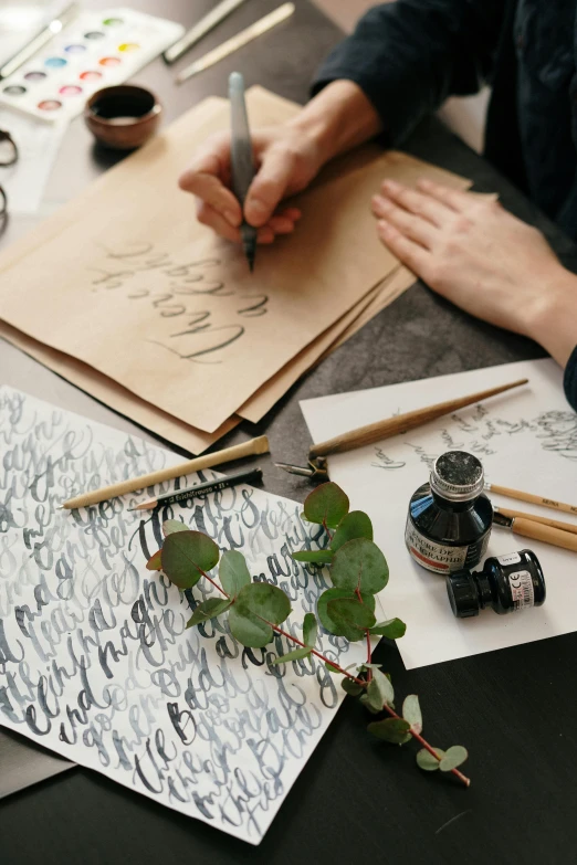 a person sitting at a table writing on a piece of paper, a still life, art & language, estrange calligraphy, thumbnail, paper craft, brown