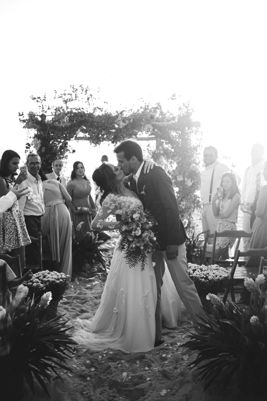 a black and white photo of a bride and groom kissing, by Robbie Trevino, gif, island, various posed, show