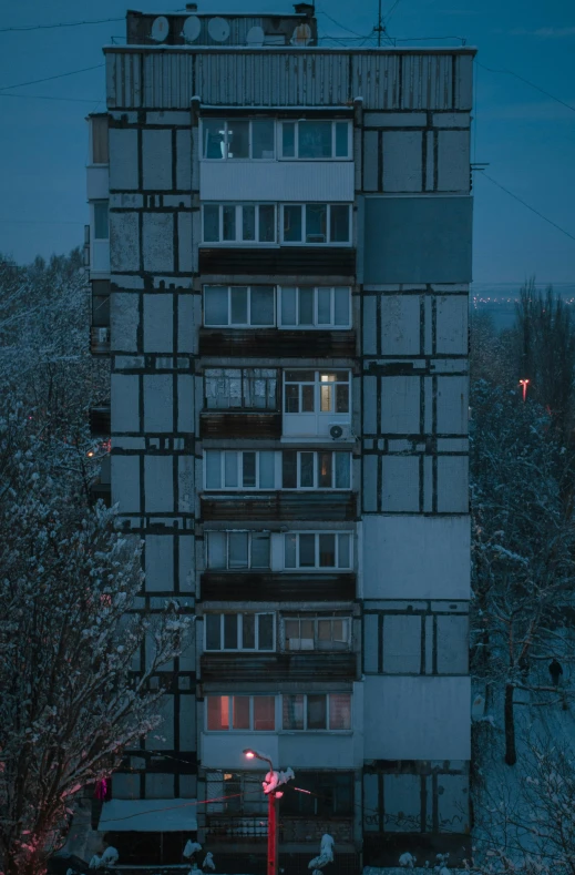 a tall building sitting on top of a snow covered field, inspired by Elsa Bleda, brutalism, soviet apartment, 8k 50mm iso 10, early evening, modular