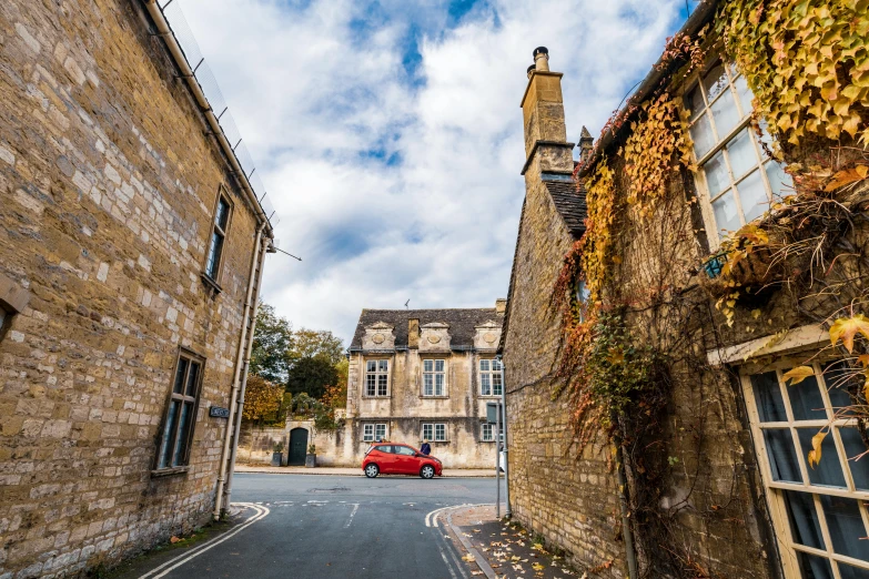 a red car parked on the side of a road, by Simon Marmion, pexels contest winner, quaint village, daniel oxford, beige, during autumn