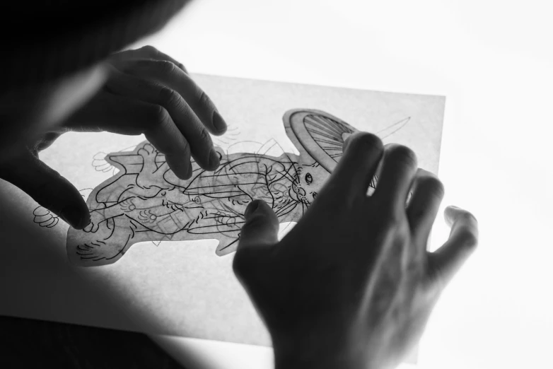 a person is drawing on a piece of paper, a detailed drawing, by Adam Marczyński, internal contours, cartoonish, press shot, 🦑 design