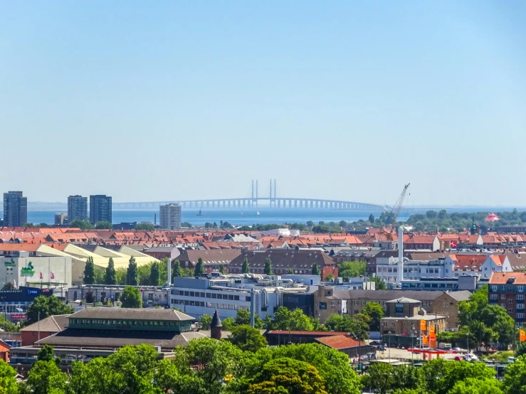 a view of a city with a bridge in the background, in a sunny day, jörmungandr, high quality image”