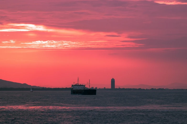 a large boat floating on top of a body of water, by Carey Morris, pexels contest winner, romanticism, redpink sunset, new york harbour, nuclear sunset, slide show