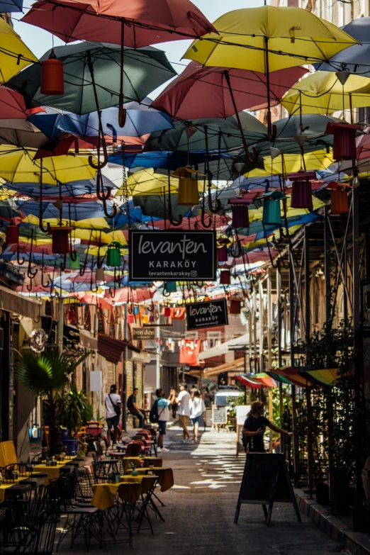 a street filled with lots of different colored umbrellas, shady alleys, things hanging from ceiling, in the sun, georgic