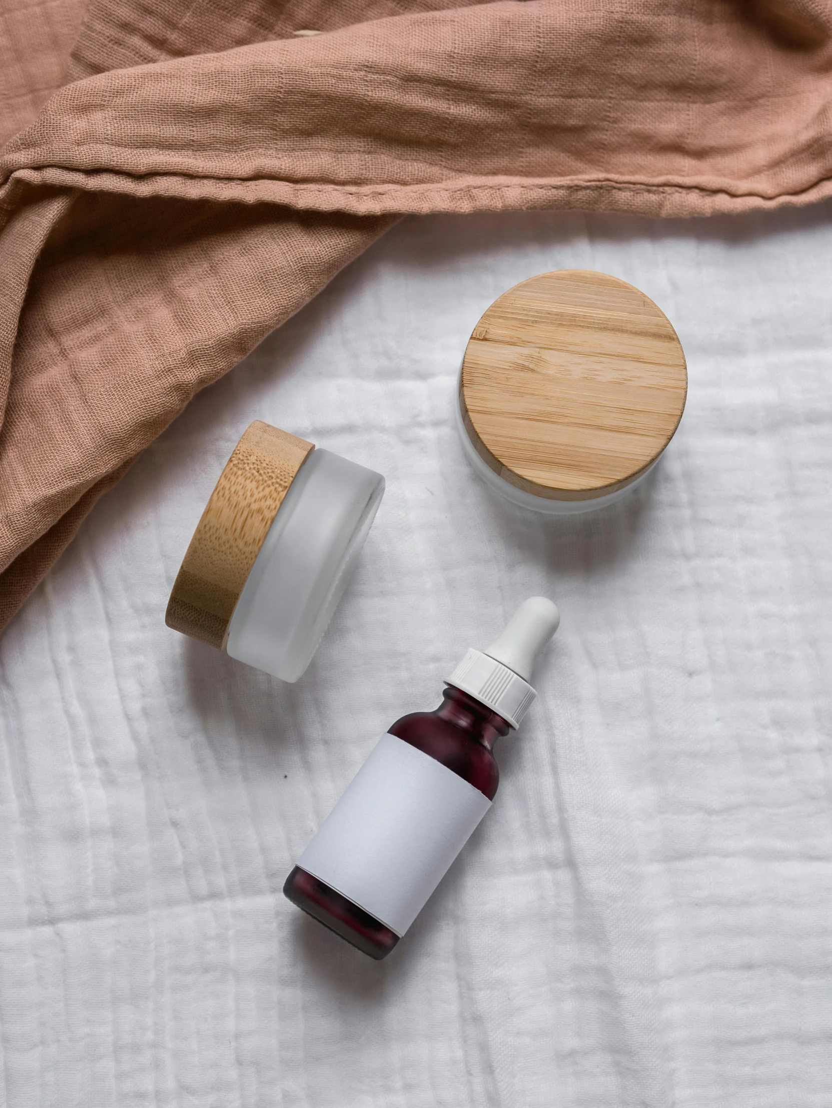 a bottle of liquid sitting on top of a bed, by Eleanor Best, face mask, bamboo wood, maroon, high resolution photograph