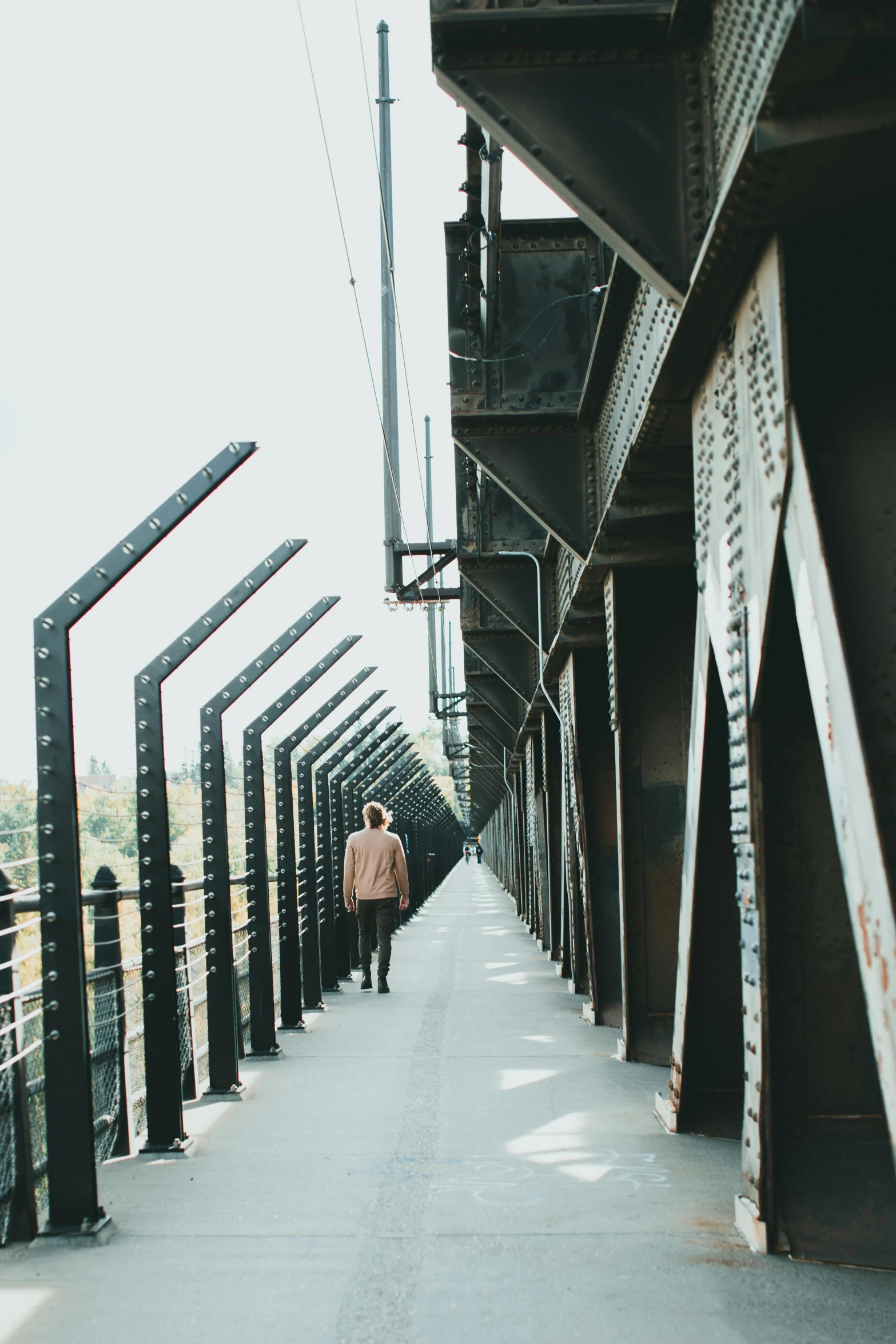 a person that is walking on a bridge, industrial space, looking straight ahead, instagram post, tall metal towers