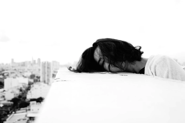 a black and white photo of a woman sleeping on a ledge, a black and white photo, happening, woman crying, head shoot, woman with black hair, 15081959 21121991 01012000 4k