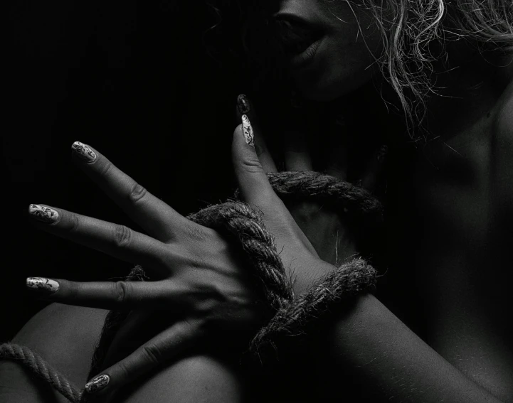 a black and white photo of a woman tied up, a black and white photo, trending on pexels, black hands with black claws, album cover, intimate, black woman