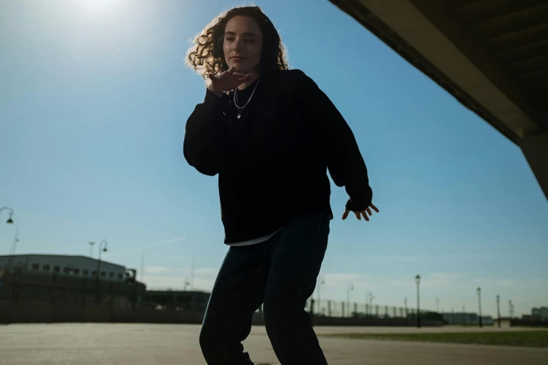 a woman riding a skateboard while talking on a cell phone, by Jacob Toorenvliet, unsplash, happening, frank dillane as puck, wide angle dynamic portrait, wearing jeans and a black hoodie, skies behind