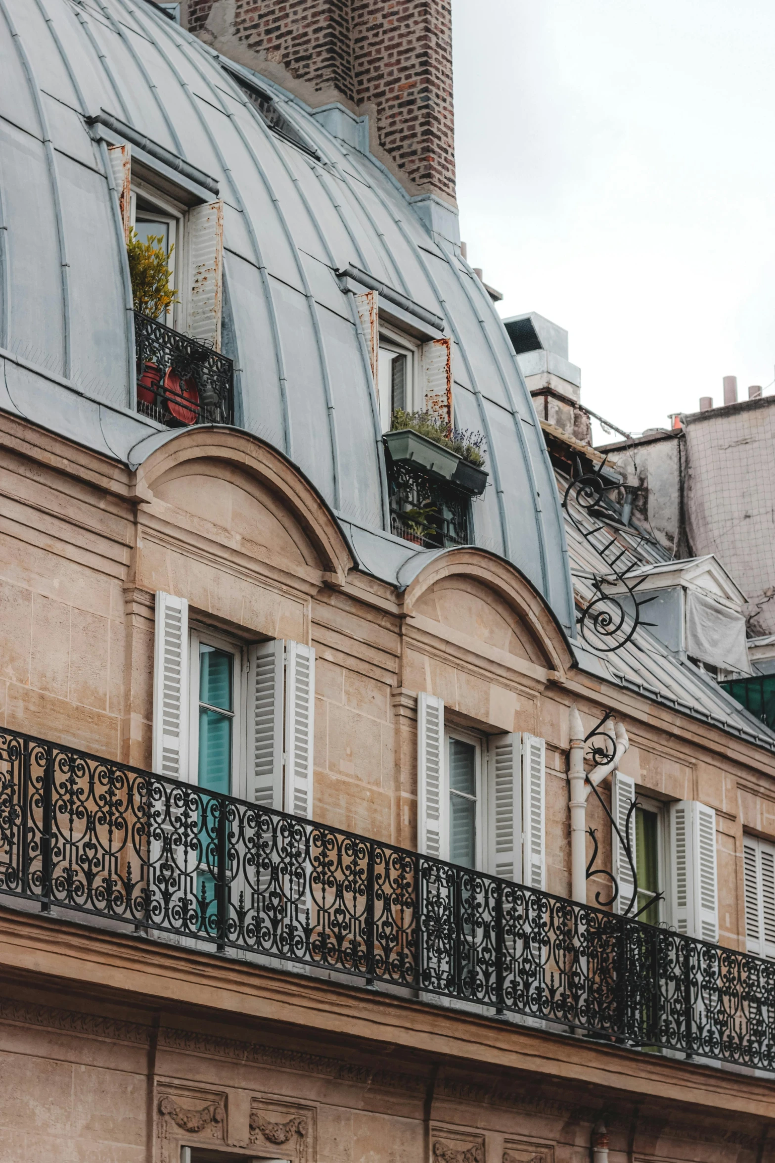 a building with a clock on the top of it, a photo, by Andrée Ruellan, trending on unsplash, art nouveau, gambrel roof building, crenellated balconies, awnings, directoire style