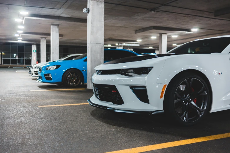 a white car parked in a parking garage, pexels contest winner, white + blue + gold + black, muscle cars, twins, avatar image