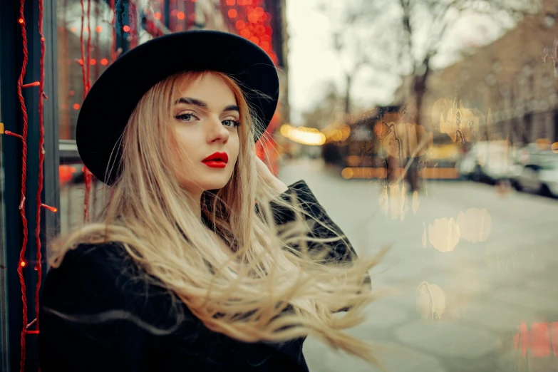 a woman with long blonde hair wearing a black hat, inspired by Elsa Bleda, trending on pexels, red lipstick, dazzling lights, street pic, sydney sweeney