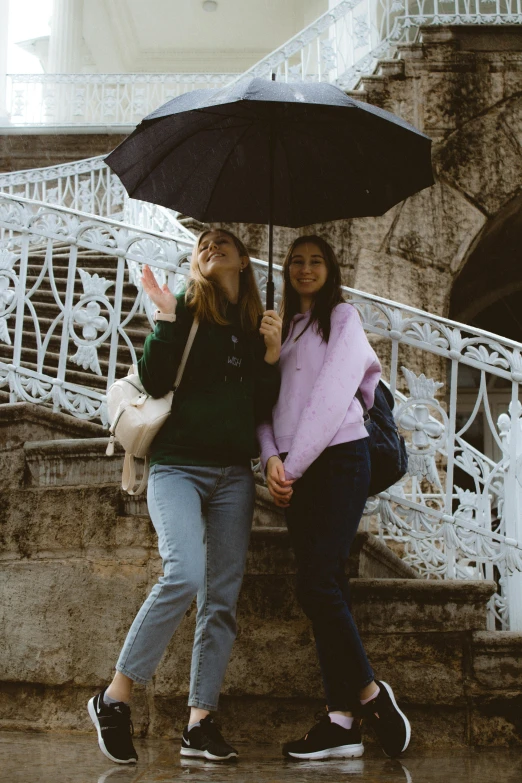 a couple of women standing next to each other under an umbrella, trending on unsplash, happening, walking down a marble stairwell, ireland, teenage girl, slide show