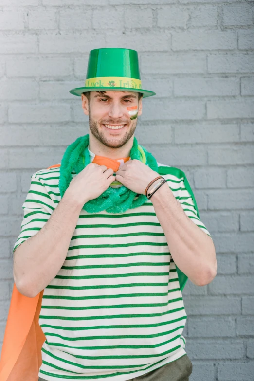 a man wearing a green hat and a green scarf, inspired by Mór Than, pexels contest winner, wearing stripe shirt, jock, clover, green and orange theme