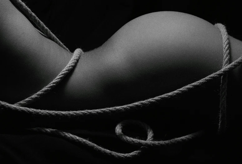 a black and white photo of a woman tied up, inspired by Robert Mapplethorpe, unsplash, figurative art, curvaceous. detailed, rope, making love, photo of a black woman