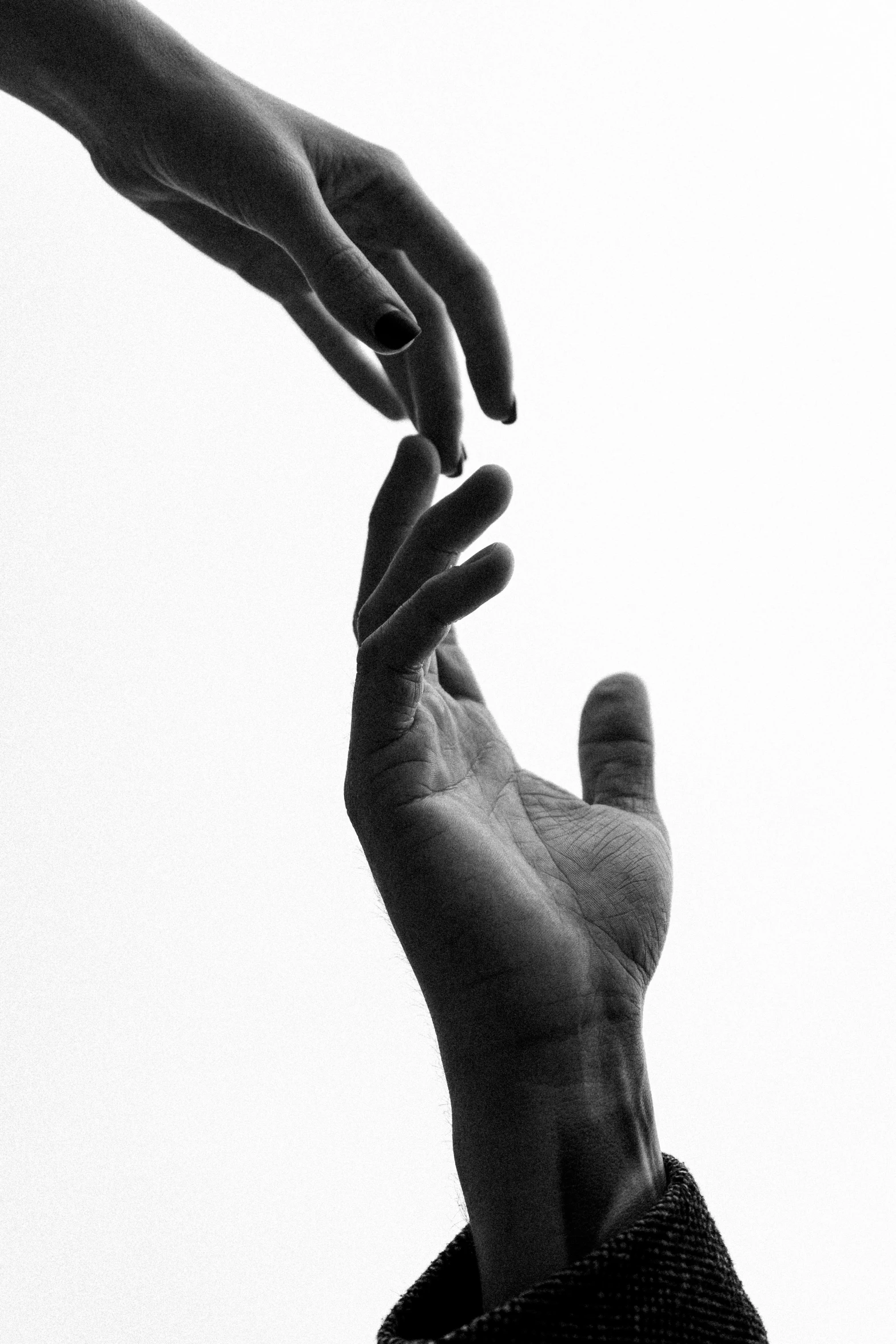 a black and white photo of two hands reaching for each other, by Alexis Grimou, unsplash, ffffound, the lovers, high key, artem chebokha