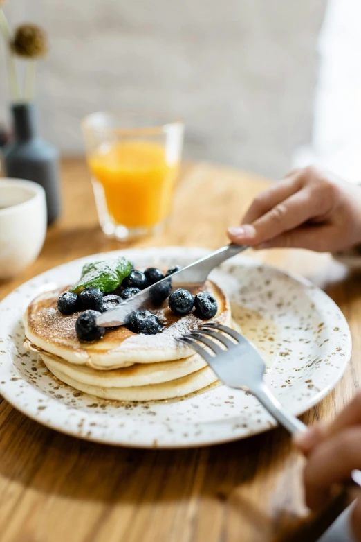 a person sitting at a table with a plate of pancakes, pexels contest winner, blueberries on the side, cutlery, manuka, breakfast buffet