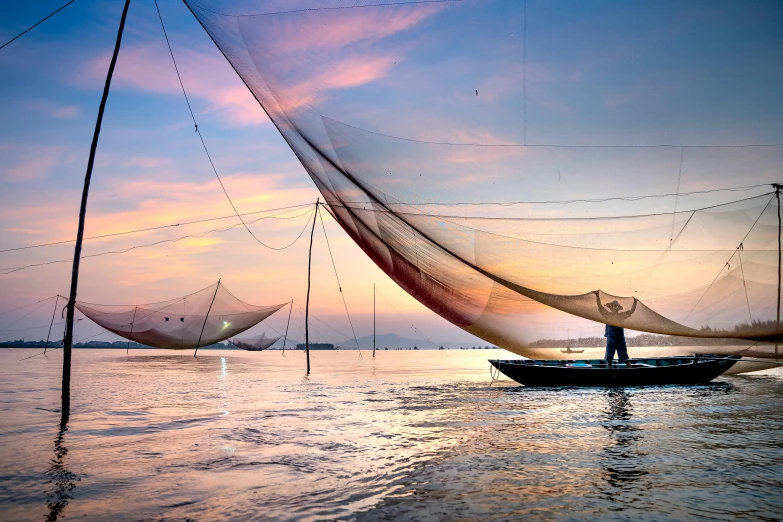 a man standing on top of a boat in the water, inspired by Steve McCurry, pexels contest winner, nets and boats, in style of lam manh, panoramic shot, soft glow