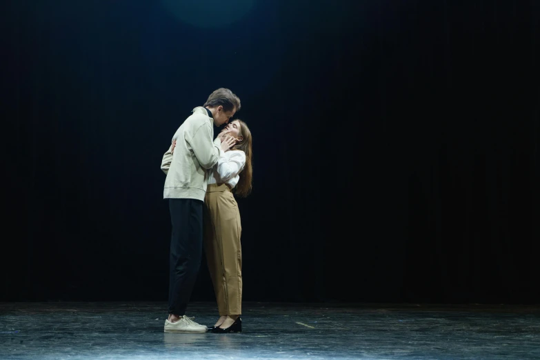 a couple standing next to each other on a stage, unsplash, realism, hugging, ignant, ( ( theatrical ) ), studio lit