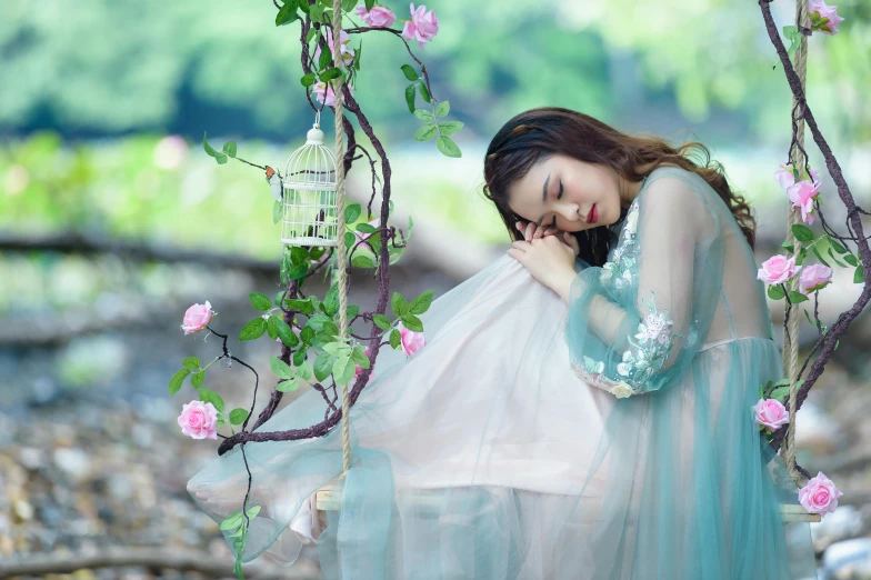 a woman that is laying down in a dress, trending on pixabay, romanticism, vietnamese woman, pink and blue and green mist, on a branch, asleep