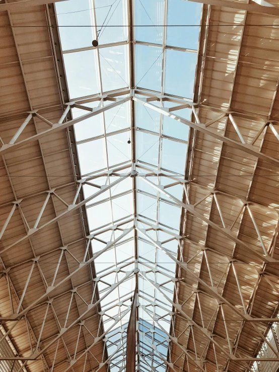 a view of the inside of a train station, by Carey Morris, unsplash, light and space, simple gable roofs, sustainable materials, seen from below, interior of a tent