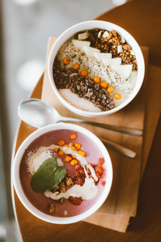 two bowls of food sitting on top of a wooden table, vanilla smoothie explosion, splento, high-quality photo, ayne haag