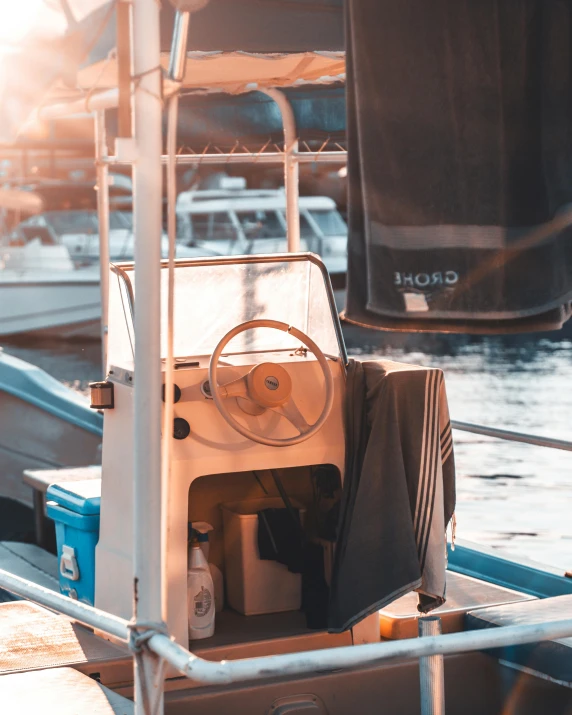 a boat sitting on top of a body of water, in the sun, vehicles, up close