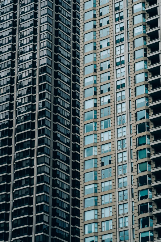a couple of tall buildings next to each other, by Andrew Domachowski, unsplash, modernism, black windows, 15081959 21121991 01012000 4k