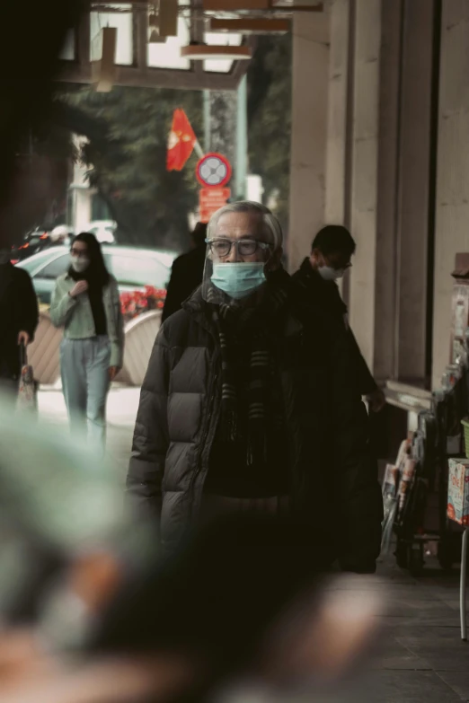 a woman wearing a face mask walking down a street, a picture, pexels contest winner, happening, man with glasses, cold scene, people shopping, old male
