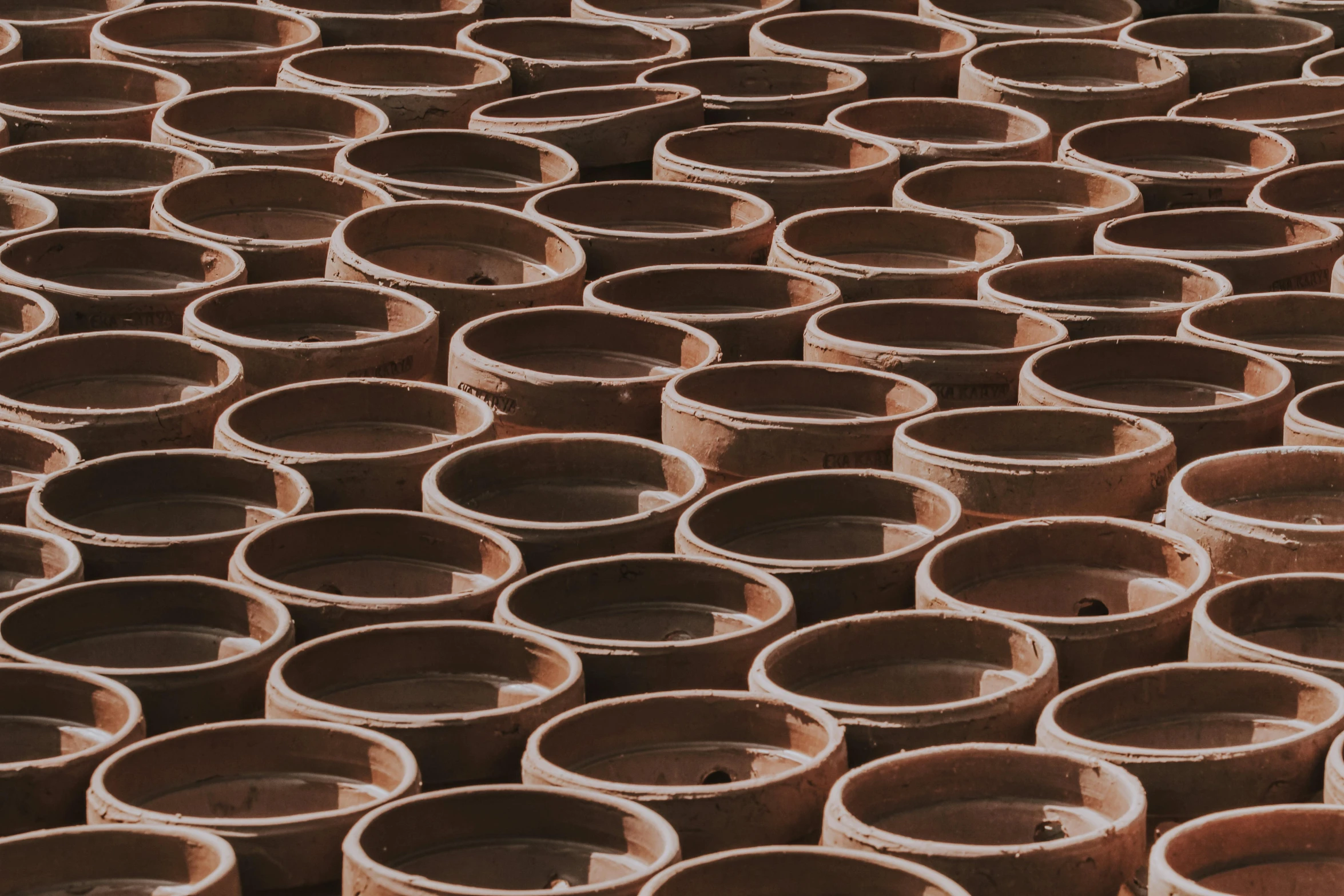 a group of clay pots sitting next to each other, inspired by Ai Weiwei, trending on unsplash, land art, zoomed out to show entire image, subtle pattern, 35 mm product photo”, pipe