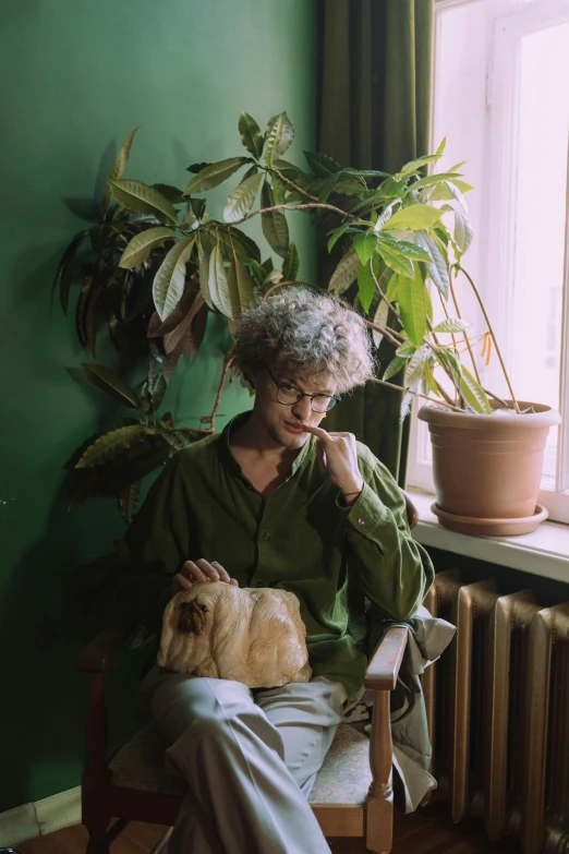 a woman sitting in a chair in front of a window, an album cover, inspired by Elsa Bleda, pexels, short unkempt green hair, cats and plants, curly haired, lesbians
