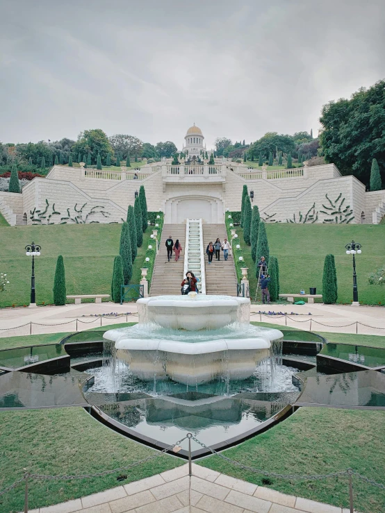 a large fountain sitting in the middle of a lush green park, inspired by Kurt Wenner, pexels contest winner, staggered terraces, islamic, snapchat photo, 2000s photo