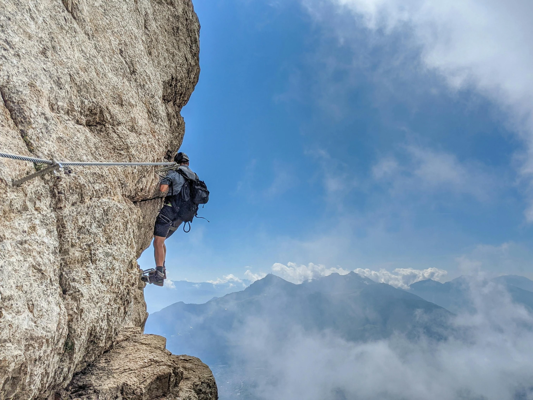 a man climbing up the side of a mountain, by Andries Stock, pexels contest winner, on clouds, avatar image, hanging rope, 2 0 2 2 photo