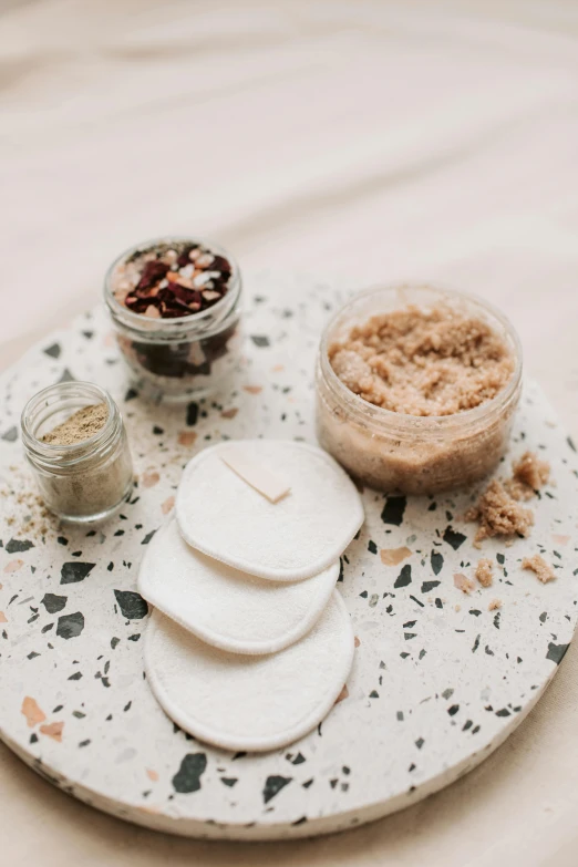 a close up of a plate of food on a table, by Alice Mason, unsplash, jars, soap, textured base ; product photos, terrazzo