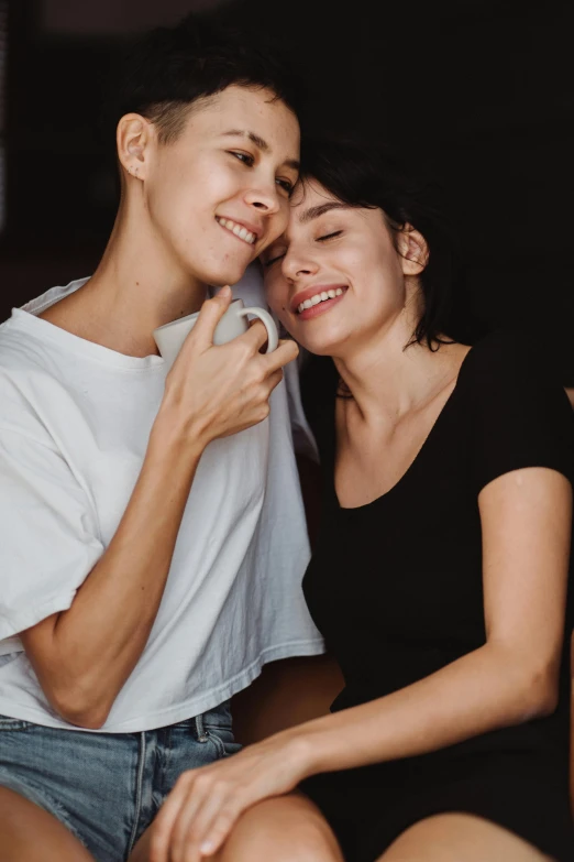 a man and a woman sitting next to each other, trending on pexels, antipodeans, lesbian embrace, buzzed short dark hair, young women, dimples