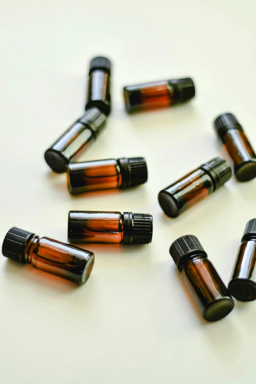 several bottles of essential oils on a white surface, by Linda Sutton, pexels, thumbnail, enhanced, miniatures, brown