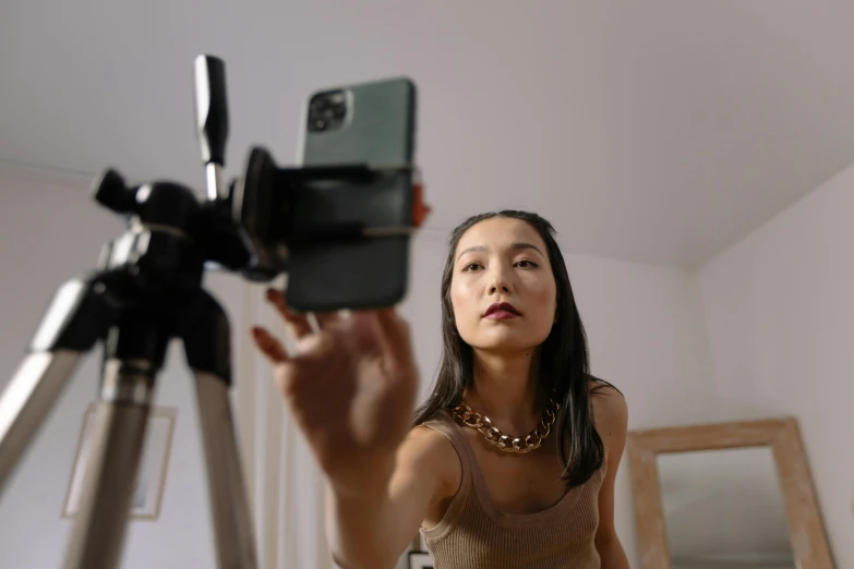 a woman taking a picture of herself with a camera, trending on pexels, realism, gemma chan, avatar image, smartphone footage, low angle wide shot