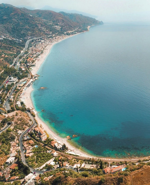 a large body of water next to a beach, pexels contest winner, renaissance, taormina amphitheatre, helicopter view, thumbnail, drag