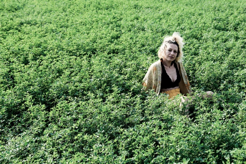 a woman sitting in a field of green plants, an album cover, by Pamela Ascherson, land art, mrs bean, madonna, taken in the late 2010s, clover