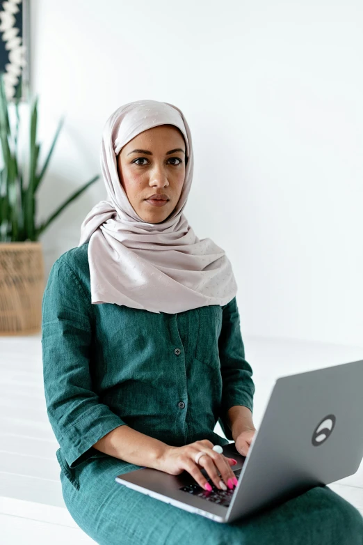 a woman sitting on a bed using a laptop, inspired by Maryam Hashemi, hurufiyya, looking serious, tech demo, profile image, modest