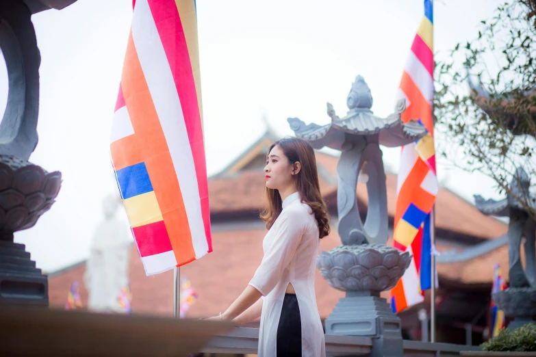 a woman standing in front of a bunch of flags, inspired by Ruth Jên, unsplash, thai architecture, square, avatar image, dilraba dilmurat