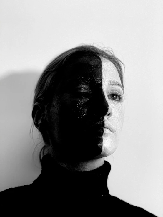 a woman with black paint on her face, a black and white photo, by Caroline Mytinger, half and half, shadow effect, ellie bamber, image split in half