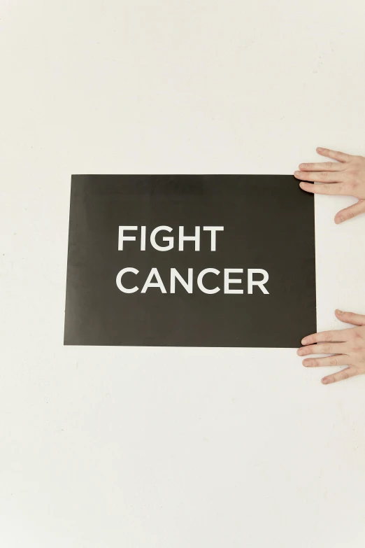 two hands holding a sign that says fight cancer, an album cover, by Julia Pishtar, pexels contest winner, matte black paper, fighting stance energy, large format picture, 2 0 0 0 s