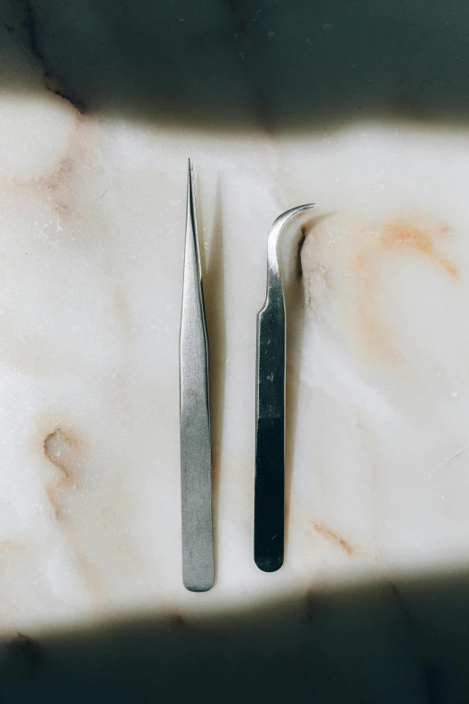 a couple of tools sitting on top of a marble counter, natural straight eyebrows, unclipped fingernails, stainless steel, detailing